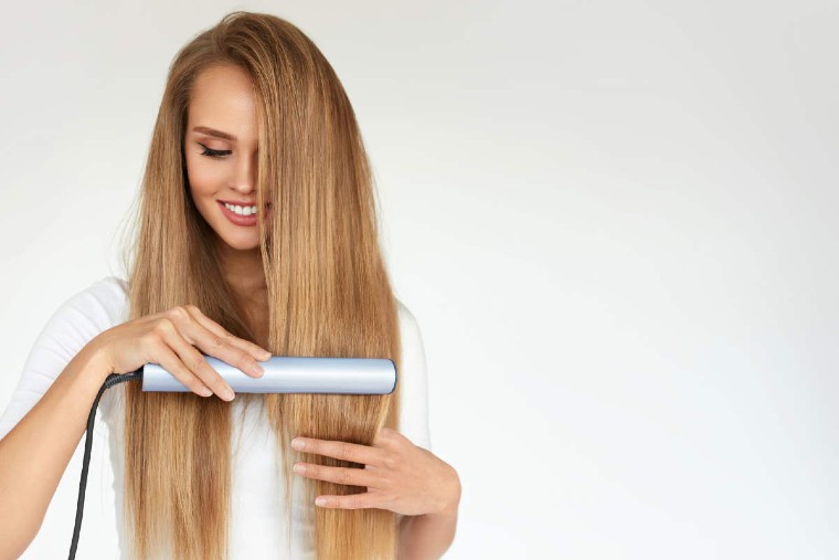 beautiful-girl-is-using-hair-straightener-smiling-while-looking-into-mirror-home-smiling-woman-straightening-hair-with-hair-straightener