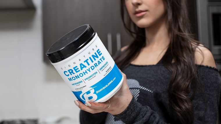 woman holding a package of creatine monohydrate
