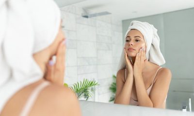 woman putting natural skincare products on her face