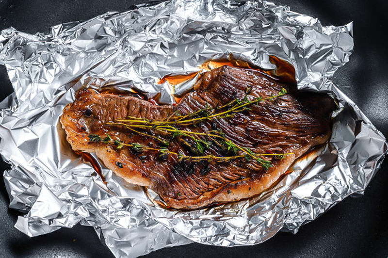 meat in aluminium foil smoked in smoker grill