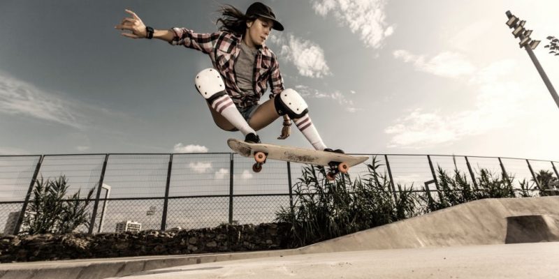 picture of a girl riding a skateboard with knee pads