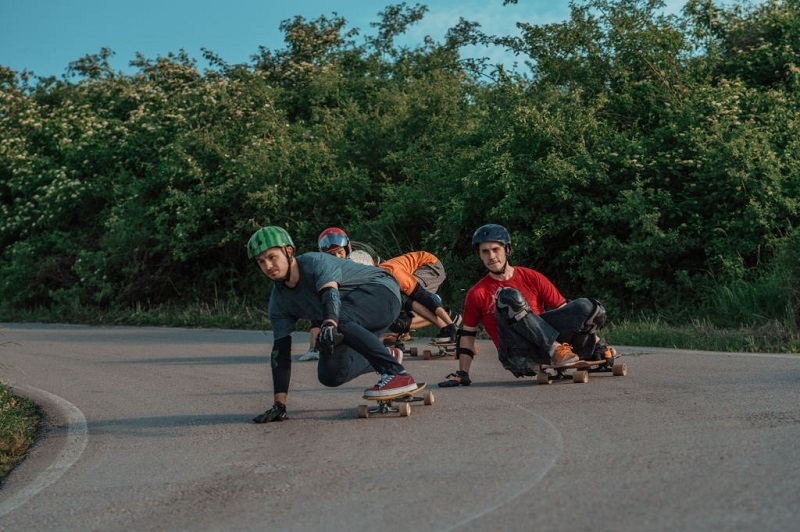 picture of boys riding a skateboards on a concrete whit full gear