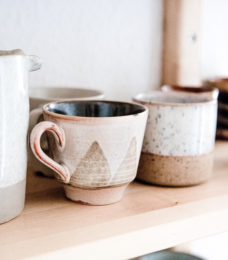 handmade mugs on wooden shelf 