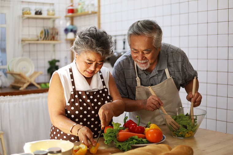happy senior couple cooking healthy food to improve memory