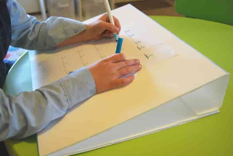 Kid writing on the slant board