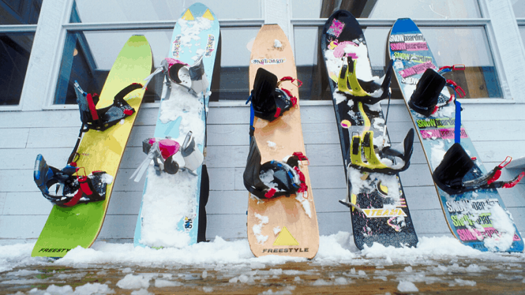 different snowboards with snowboard bindings on them 