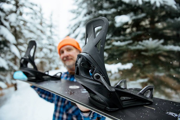 man holding snowboard bindings close up