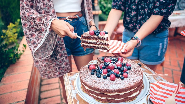 cutting a slice of a naked cake