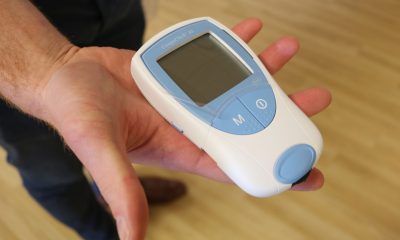 picture of person holding an INR Machine in his hand while standing on parquet