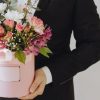 Man is holding box of flowers as a gift