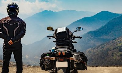 Man standing by his motorcycle with luggage on mountain