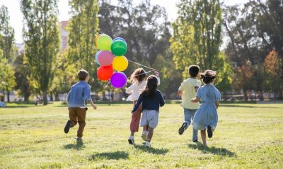 kids running in a yard with balloons