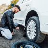 man changing tire of his car