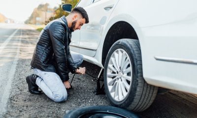 man changing tire of his car