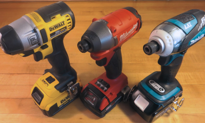 Assortment of Dewalt, Milwaukee, and Makita cordless power drills on wooden surface.