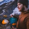 Man eating back country meal while camping