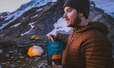 Man eating back country meal while camping