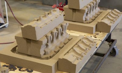 Sand casting molds for engine parts arranged on a wooden pallet in a workshop.